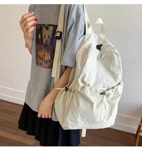 Detail view of water-resistant nylon backpack with adjustable side buckles and drawstring pocket