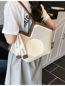 Sac cabas ajouré crème avec bordure marron et logo, porté à l'épaule par un mannequin
