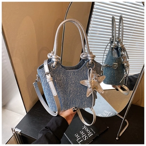 Detail of blue denim texture handbag with sparkling finish and silver star pendant