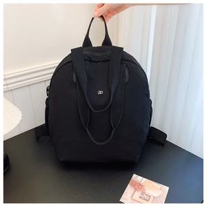 Detail of waterproof black nylon backpack with top handle and silver metal DD logo hardware
