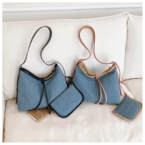 Denim hobo tote bags with leather trim and matching coin pouches shown on a sofa