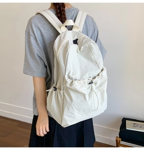 Detailed view of lightweight nylon backpack with functional drawstring pockets on model