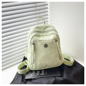 Détails du sac à dos en nylon vert menthe clair montrant les poches et le logo métallique