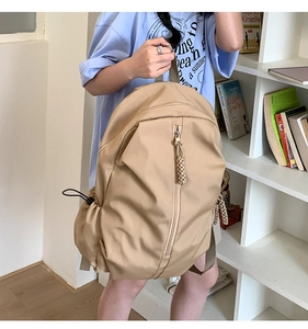 Detail view of khaki large capacity backpack with vertical zipper and side drawstring pockets
