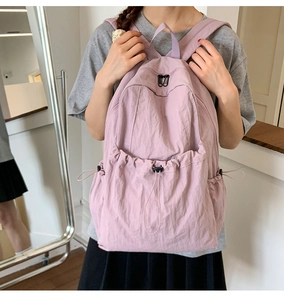 Detail of light purple nylon backpack with drawstring pocket and smooth dual zippers