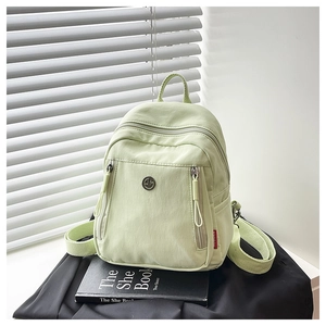 Vue détaillée du mini sac à dos en nylon vert menthe avec poche avant et fermetures