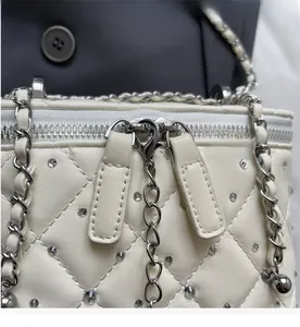 Close-up of quilted diamond pattern crossbody bag with silver rhinestones and smooth zipper