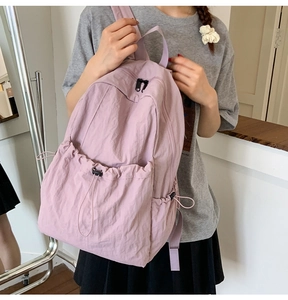 Detailed view of light purple nylon backpack with drawstring pockets and lightweight design