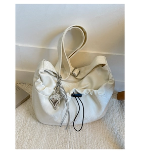 Detail of soft cream PU leather handbag with silver heart charm and drawstring feature