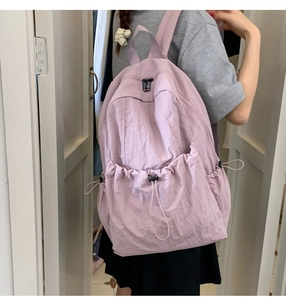 Detailed view of lilac nylon backpack with drawstring pocket and smooth dual zippers