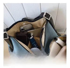 Interior view of denim tote bag showing spacious capacity with silver buckle strap