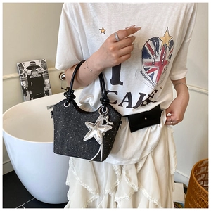 Detailed shot of dark grey polka dot handbag with silver star charm and black handle