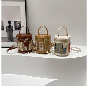 Detailed view of woven bucket bags in dark brown, camel and beige with metal zippers