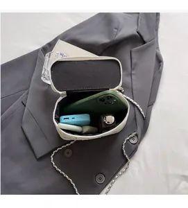 Close-up of a white quilted chain bag showing large interior space for phone and makeup