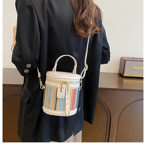 Close-up of woven bucket bag with colorful patterns and premium white leather details