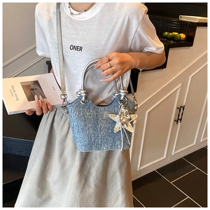 Detail of light blue glitter bucket bag with silver top handles and star charm