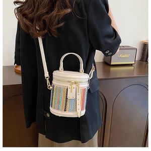 Detail of bohemian bucket bag featuring colorful woven patterns and elegant gold hardware