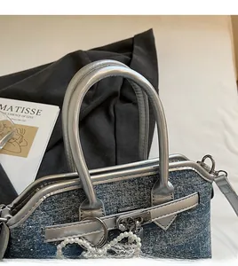 Gros plan sur la poignée en denim avec garniture argentée et chaîne de perles chic