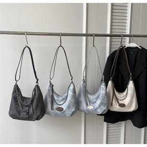 Detailansicht der Denim-Hobo-Taschen in Dunkelgrau, Hellblau und Beige mit Metallketten