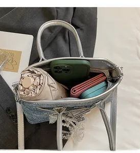 Détail de l'intérieur du sac en denim pailleté montrant le rangement du parapluie et du mobile