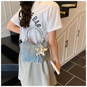 Close-up of light blue denim handbag with silver handles and a sparkling star charm