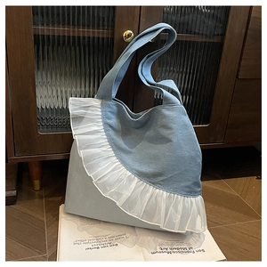 Detailed side view of large denim tote bag featuring multi-layer lace floral trim