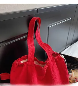 Detail of red drawstring tote bag with water-resistant fabric and wide strap