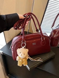 Borsa a bauletto trapuntata rosso scuro con ciondolo a orsetto e tracolla