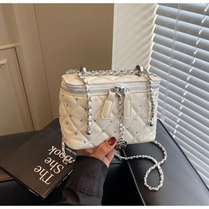 Detail of white quilted box bag with sparkling rhinestones and silver rose charm
