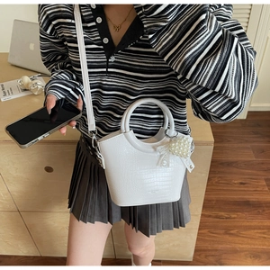 Detailed texture of white crocodile pattern PU handbag with lace and pearl charm