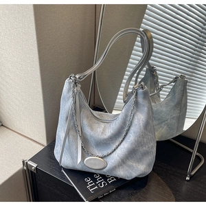 Detailansicht der hellblauen Denim-Hobo-Tasche mit Silberkette und Metall-Applikationen