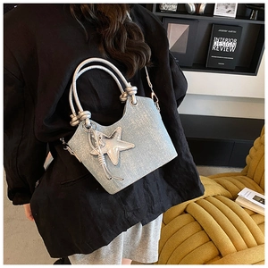 Detail of light blue glitter bucket bag with silver round handle and star pendant charm