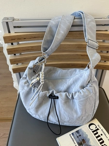 Light blue pleated dumpling crossbody bag with drawstring and silver heart charm decoration