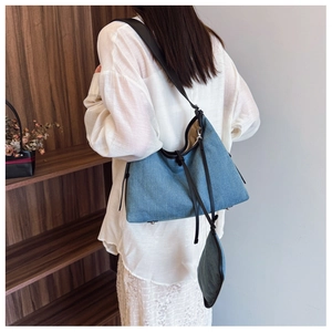 Detail of denim tote bag with leather strap and a small detachable coin purse pouch