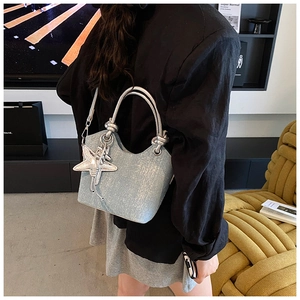 Detail of light blue sequin bucket bag with star pendant and silver circular handle
