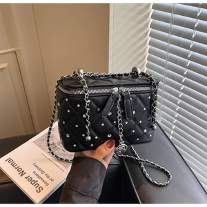 Close-up of black quilted bag with rhinestones, silver zippers and leather chain strap