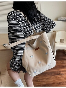 Large beige canvas tote bag featuring embroidered dachshund dogs and brown leather logo tag