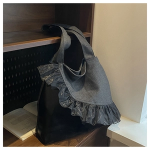 Macro shot of large denim tote bag featuring black lace ruffle trim and gray patchwork