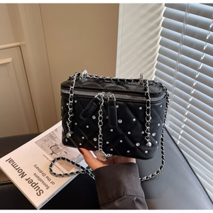 Close-up of black quilted crossbody bucket bag featuring sparkling white rhinestones