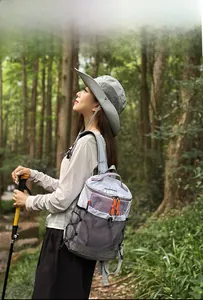 Outdoor backpack detail showing grey and purple panels with mesh side pockets in a forest