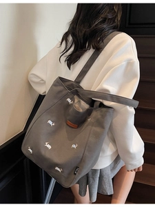 Dark grey canvas tote bag featuring colorful puppy embroidery and dual shoulder straps