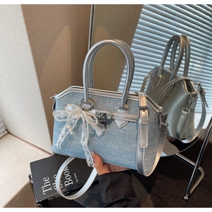Détail du sac en jean bleu clair avec strass étincelants et nœud en dentelle à perle