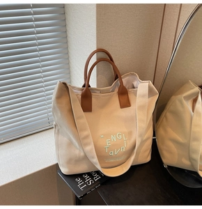 Détail du sac cabas en toile avec poignées en cuir marron et broderie ENGL TAVNI