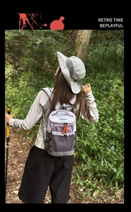 Close-up of lightweight outdoor hiking backpack with orange zipper pulls in forest setting