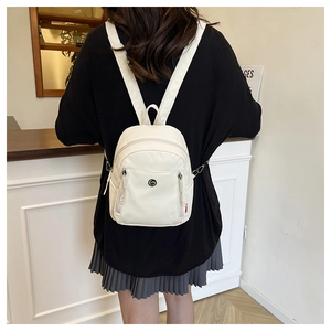 Vue détaillée du mini sac à dos blanc en nylon avec logo métallique et bretelles réglables