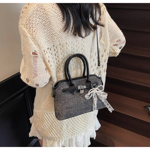 Détail du sac en denim à paillettes avec nœud en dentelle et breloque en perles