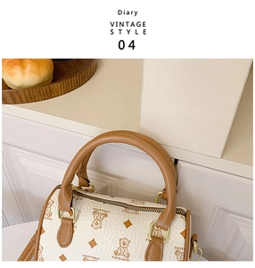 Detail of cream Boston bag featuring brown bear patterns and premium lychee leather texture