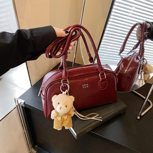 Sac bowling en cuir verni bordeaux avec doubles poignées et charm d'ours en peluche