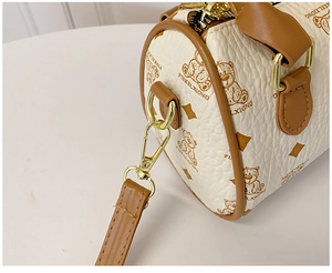 Detail showing the white pebbled faux leather texture and brown bear pattern on a mini bag