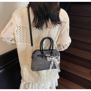 Vue détaillée du sac à main gris scintillant avec nœud en dentelle blanche et cadenas en métal